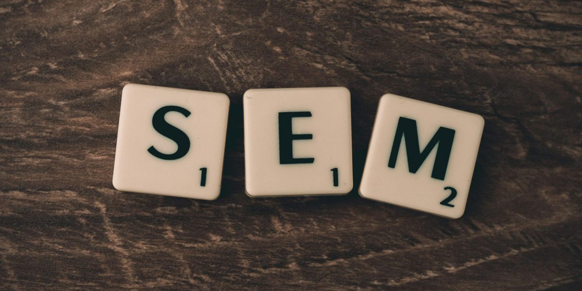 Wooden background with letter tiles spelling SEM, representing search engine marketing.